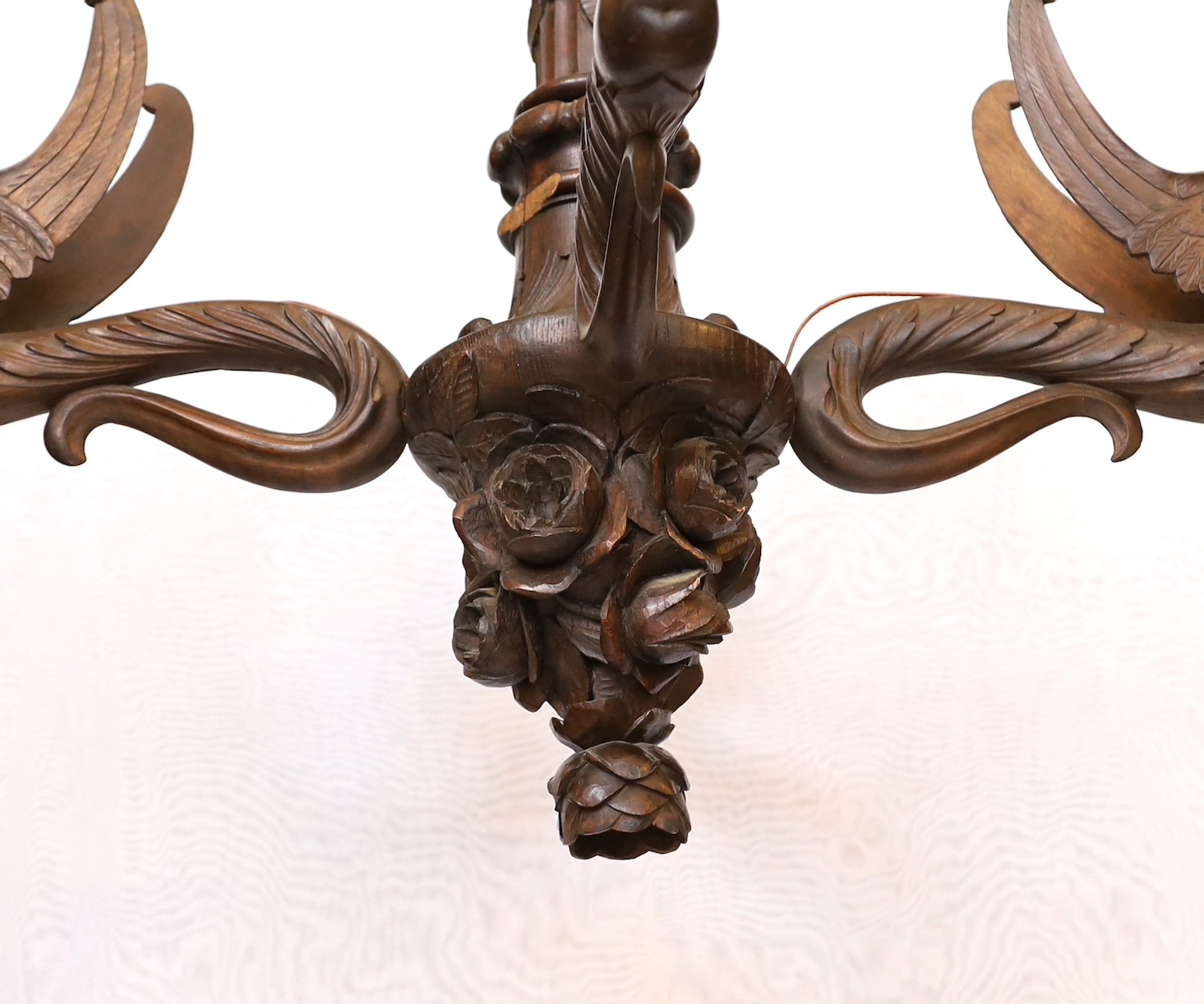 A Swiss Black Forest carved wood four light chandelier with caryatid branches and rose entwined stem, height 92cm. width 92cm